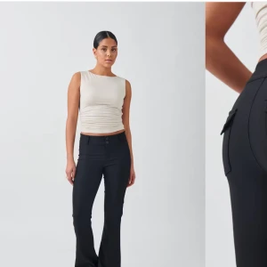 Svarta kostymbyxor - Snygga svarta kostymbyxor i mycket bra skick. De är midwaist och har en slim passform som ger en elegant look. Byxorna har knappar på bakfickorna och är perfekta för både kontoret och festliga tillfällen. Ett måste i garderoben för en stilren outfit!