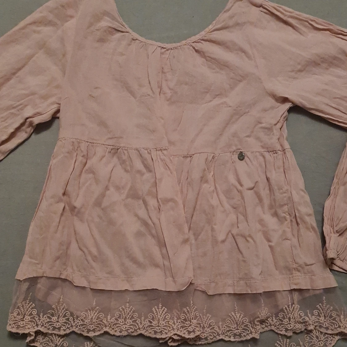 Ljusrosa blus med spetsdetaljer