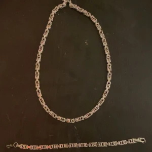 Silverfärgat halsband och armband - Säljer ett stilrent set med halsband och armband i silverfärg. Båda har en länkdesign 