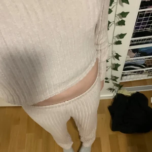 Beige ribbad hoodie och byxor set - Mysigt set med en beige ribbad hoodie och matchande byxor. Perfekt för en chill dag hemma eller en avslappnad utflykt. Hoodien har långa ärmar och en bekväm passform. Byxorna är också ribbade och ger en skön känsla. Perfekt för höst och vinter!