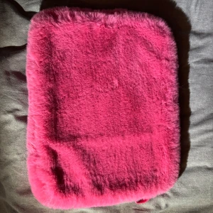 Rosa fluffig datorväska - Säljer en supermjuk och fluffig rosa datorväska som är perfekt för att skydda din laptop. Den har en dragkedja för säker förslutning och är fodrad för extra skydd. Passar perfekt för att ge din dator en mysig och stilren look. Perfekt för både vardag och resa!