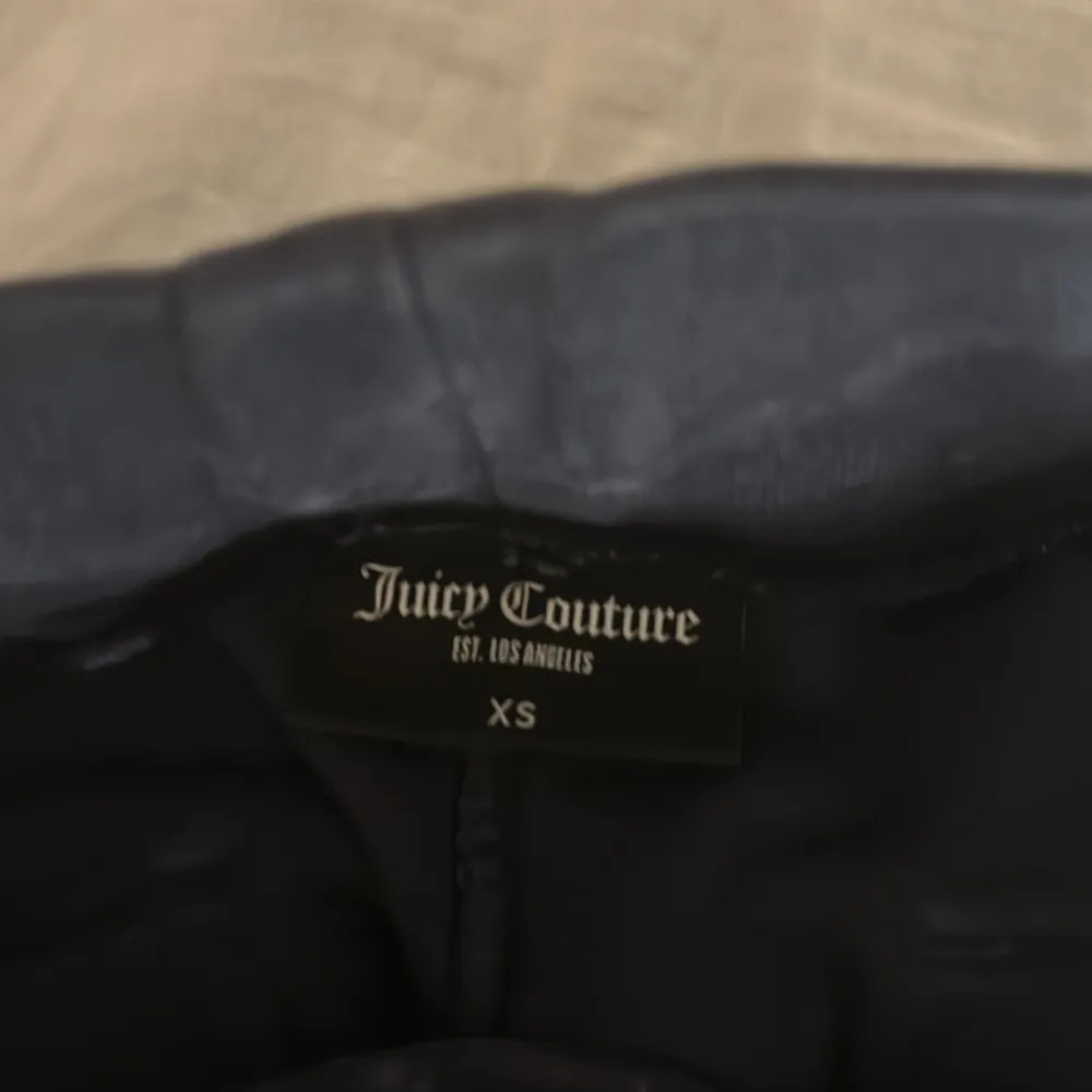 Säljer ett par mörkblå byxor från Juicy Couture i storlek XS. Byxorna är i mjukt material och har fickor med knappar bak. Bra skick. . Jeans & Byxor.