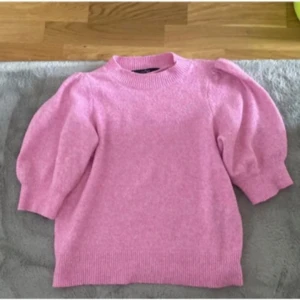 Rosa stickad tröja - Säljer en superfin rosa stickad tröja med puffiga trekvartsärmar. Perfekt för både vår och höst! Den har en rund halsringning och ribbade kanter som ger en snygg passform. Passar perfekt till jeans eller kjol för en söt och avslappnad look. 💖
