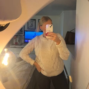 Vit stickad tröja - Mysig vit stickad tröja perfekt för kyliga dagar. Den har ett snyggt flätmönster och långa ärmar. Passar både till vardags och lite finare tillfällen. Superbekväm och stilren!