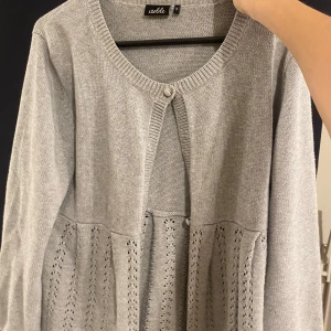 Grå kofta från Wolt - Säljer en superfin grå kofta från Wolt i storlek S. Den har ett snyggt hålmönster nedtill och en knapp framtill. Perfekt för både vår och höst! 🩶