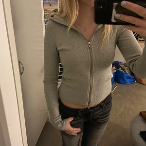 Tajt ribbad huvtröja - Grå ribbad, tajt kofta med huva från Weekday i storlek XS. Använd fåtal gånger