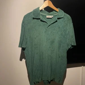 Grön pikétröja från Weekday - Säljer en snygg grön pikétröja från Weekday i storlek M. Tröjan är i frotté och har en klassisk krage med korta ärmar. Perfekt för en avslappnad stil under vår och sommar. Skön och lätt att matcha med jeans eller shorts!