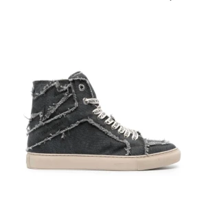 Grå sneakers i jeansmaterial - Säljer ett par grå sneakers i jeansmaterial med coola fransiga detaljer. Skorna har en hög modell med snörning och en bekväm vit sula. Perfekta för en avslappnad och trendig look. Passar både till vardags och fest!