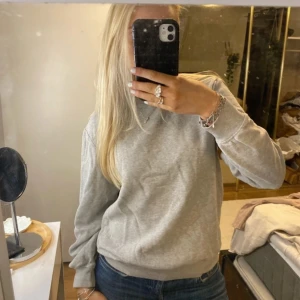 Grå sweatshirt - Säljer en mysig grå sweatshirt i bra skick. Perfekt för vardagsbruk med normal passform och långa ärmar. Enkel och stilren design som passar till det mesta. Perfekt för höst och vår!