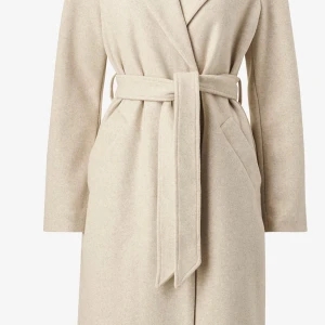 Beige kappa med bälte - Säljer en elegant beige kappa i ull med bälte i midjan. Perfekt för höst och vår, med långärmad design och en klassisk stil. Kappan har en stilren look och är superbekväm att bära. Passar både till vardags och festliga tillfällen.  