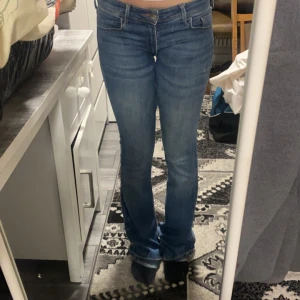 Blå bootcut jeans - Säljer ett par snygga blå bootcut jeans i bra skick. De är lågmidjade och har en klassisk femficksdesign. 