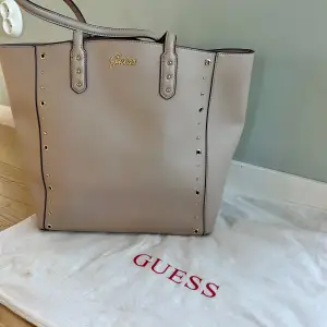 Säljer min guess väska pga att den inte kommer till användning. Används fåtal gånger. Köpt i guess butik för några år sedan. Kommer med en Guess-dustbag för förvaring. 