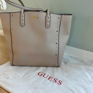  Guess väska  - Säljer min guess väska pga att den inte kommer till användning. Används fåtal gånger. Köpt i guess butik för några år sedan. Kommer med en Guess-dustbag för förvaring. 