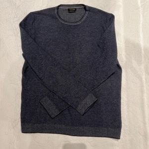 Mörkblå tröja från Massimo Dutti - Säljer en stilren mörkblå tröja från Massimo Dutti i mycket bra skick. Tröjan är långärmad och har en klassisk rund halsringning. Perfekt för både höst och vinter, och passar till både vardag och fest. Materialet känns mjukt och bekvämt mot huden.