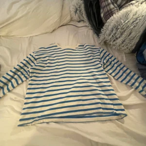 Randig tröja från Pull&Bear - Säljer en snygg randig tröja från Pull&Bear i vitt och blått. Perfekt för en avslappnad stil, med långa ärmar och mjukt material. Passar bra till både jeans och shorts. Perfekt för vår och sommar!