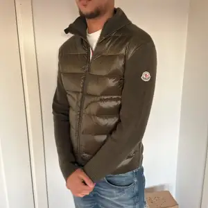 Säljer en snygg olivgrön cardigan från Moncler i mycket bra skick. Jackan har en quiltad design med dragkedja och långa ärmar. Perfekt för höst och vår, funkar även vinter. och den är både stilren och varm. Passar perfekt för dig som vill ha en jacka med både funktion och modekänsla. Köpt den här på Plick inga skador. men passar nt mig. Funkar att byta mot samma i storlek Large. 