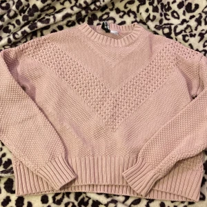 Rosa stickad tröja från H&M - Säljer en superfin rosa stickad tröja från H&M i storlek S. Den har ett snyggt mönster med olika stickade strukturer och ribbade kanter vid ärmslut och nederkant. Perfekt för kyliga dagar och passar både till vardags och lite finare tillfällen. 💖