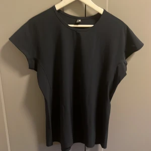 Mörkblå tröja från Helly Hansen - Säljer en mörkblå t-shirt från Helly Hansen i storlek M. Materialet är känns som golfbyxor. 