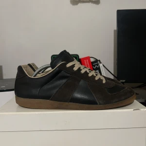 Maison Margiela GAT - Brown/black - Tja!  Säljer nu mina älskade Gat’s efter ett tag användning. Skicket är bra, fortfarande lika snygga varje gång jag sätter på mig de! Skolåda & dustbags finns självklart! Nypris: ca 6500kr Storlek: 44 passar 43  DM för fler bilder eller frågor!🧞‍♂️✨