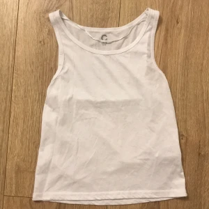Vit linnetopp för barn - Säljer en enkel och stilren vit linnetopp för barn i storlek 134/140. Perfekt för varma sommardagar eller som ett basplagg under andra kläder. Toppen är i mycket bra skick och redo för en ny ägare! OBV!!!! Linnet är lite genomskinligt.