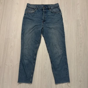 Blå jeans från HM - Säljer ett par blåa mom-jeans från HM i storlek EUR 42. De är perfekta för vardagsbruk. Jeansen har en traditionell femficksdesign och är i bra skick. Perfekta för både höst och vår!