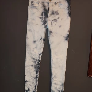 Tie-dye jeans från Monki - Säljer ett par snygga tie-dye jeans från Monki i storlek M. De har en cool blå och vit mönster och är i mycket bra skick. Perfekta för att ge din outfit en unik touch! 💙🤍