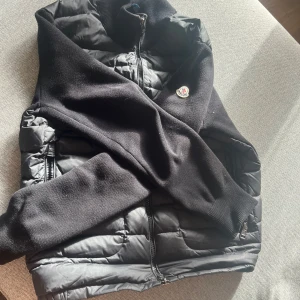 Svart dunjacka från Moncler - Säljer en snygg svart dunjacka från Moncler i mycket bra skick. Jackan har en quiltad design med dragkedja framtill och på fickorna. Perfekt för höst och vinter, håller dig varm och stilren. Passar både till vardags och lite finare tillfällen. 🖤