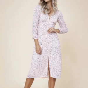 Ljusrosa blommig klänning från ADOORE  - Superfin ljusrosa klänning med små blommor och v-ringning från ADORE. Den har långa ärmar och en söt slits framtill. Perfekt för vår och sommar! 💐