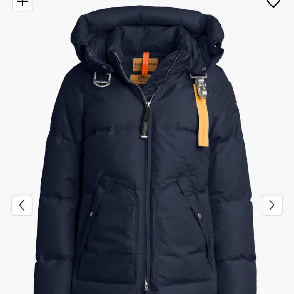 Säljer en snygg och varm mörkblå dunjacka från Parajumpers. Jackan har en praktisk huva och stängs med dragkedja. Den har långa ärmar och en cool detalj med gul rem vid halsen. Perfekt för kalla vinterdagar! 🧥❄️(äkta päls ingår!). Jackor.