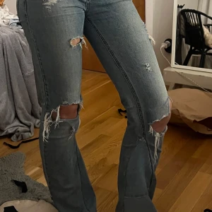 Blåa jeans - Säljer ett par blå jeans med hål och slitningar. De är booutcut och midwaist💕 