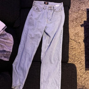 Ljusblå jeansbyxor från Dickies - Säljer ett par ljusblå jeansbyxor från Dickies i bra skick. De har en klassisk straight passform Perfekta för både vardag och avslappnade tillfällen. Byxorna har två bakfickor och en knappgylf. Superbekväma och stilrena!