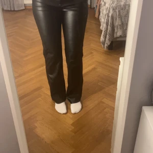 Svarta skinnbyxor från Bik Bok - Snygga svarta skinnbyxor från Bik Bok i storlek 38. De har en tight passform och är perfekta för en kväll ute. Byxorna har en knapp och dragkedja framtill. Supertrendiga och lätta att matcha med olika toppar!