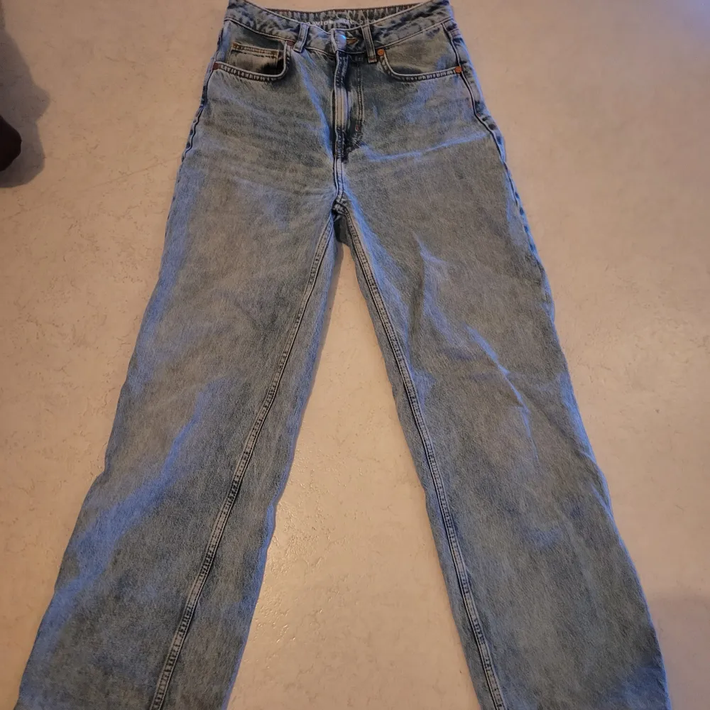 Säljer ett par snygga blå jeans från Bik Bok i modellen Tower Wide. De är högmidjade och har en avslappnad, wide fit. Perfekta för både vardag och fest! Materialet är 100% bomull vilket gör dem bekväma och hållbara. Använda men i mycket bra skick. Passa på att fynda dessa stiliga jeans! Jeansen är uppsydda men inte avklippta så det går att sprätta upp om man vill ha den längd som står i storleken.. Jeans & Byxor.