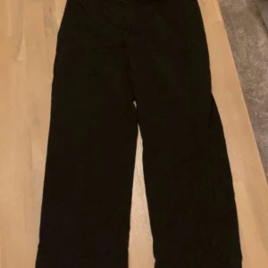 Svarta byxor - Säljer ett par svarta byxor i bra skick. De har en loose passform men sitter ändå någorlunda tajt vid låren och är perfekta för både vardag och fest. Byxorna är lågmidjade och gjorda i ett mjukt material som känns skönt mot huden. Perfekta för alla årstider!