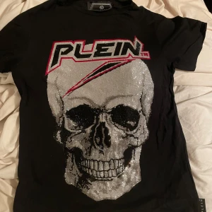  Philipp Plein t-shirt Äkta -  svart t-shirt från Philipp Plein endast använd 1 gång,säljer den då jag tröttnat på den och vill köpa något annat. 100% äkta. Medföljer tags, extra kristaller. 