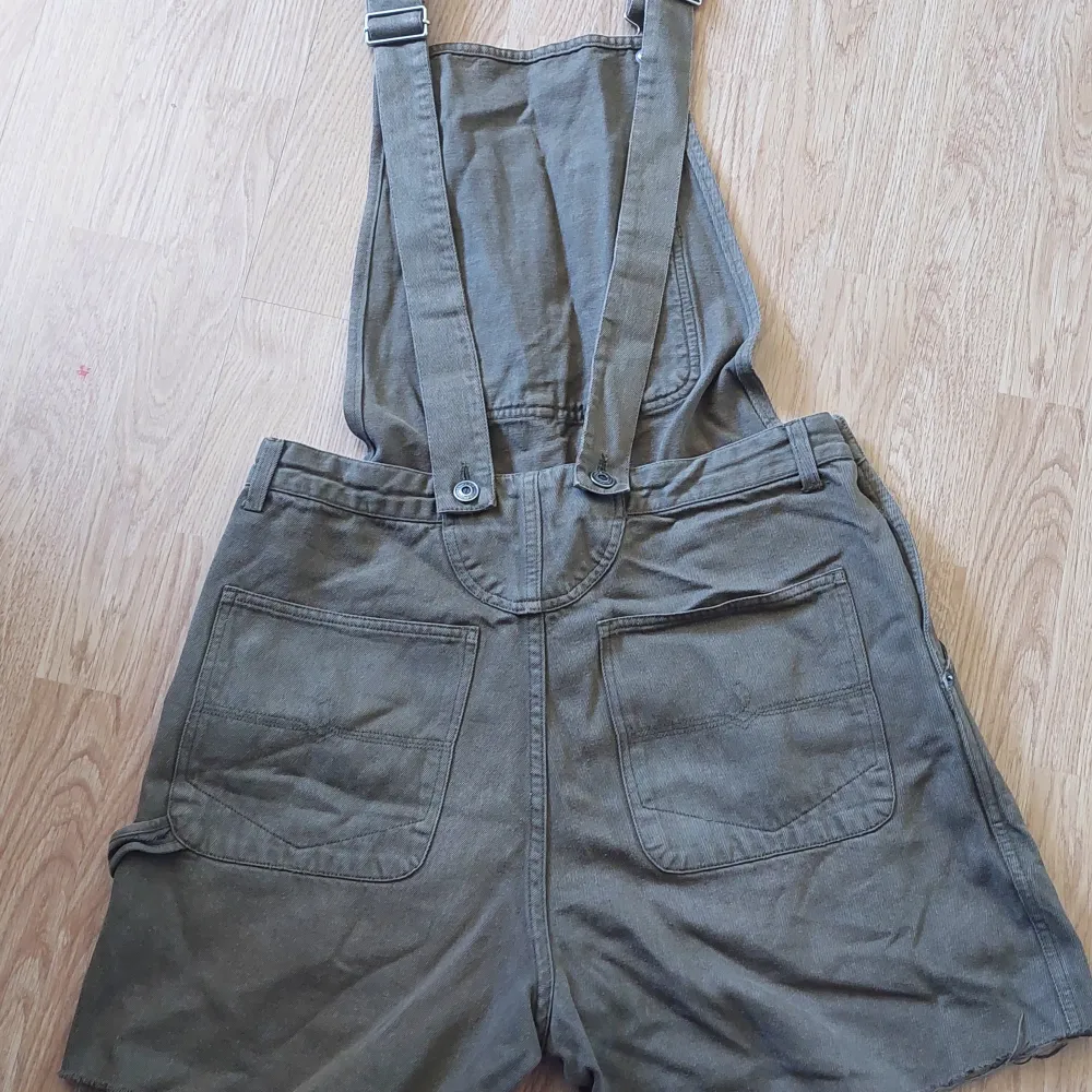 Gröna hängselshorts/snickarbyxor, tidigare köpt secondhand, på beyond retro stockholm. Storlek M, justerbara hängslen, bekväma och stilrena.. Shorts.