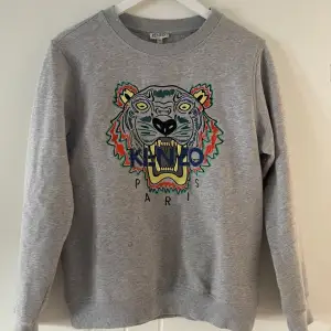 Äkta kenzo sweatshirt inköpt på Nk i Göteborg. 14y i storlek men motsvarar en XS dam! (För referens jag är 173 cm och den är inte för kort varken i ärmarna eller längden på mig) Fint skick, och riktig snygg att ha till jeans.