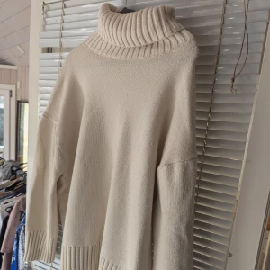 Beige stickad polotröja - Säljer en supermysig beige stickad polotröja. Den har en stor, ribbad polokrage och långa ärmar med ribbade muddar. Perfekt för höst och vinter när du vill hålla dig varm och snygg. Tröjan är i storlek L och i fint skick,nopprig dock! 