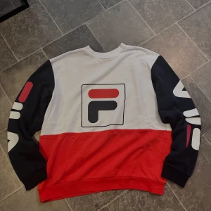 Fila tröja  - Detta är en Fila tröja i färgerna vit, rött och mörkblått. Tröjan passar alla människor oavsett ålder eller kön! Skicket är 10/10. Tröjan är i stolek L och köptes för 699kr. Pris går att diskuteras!🥂