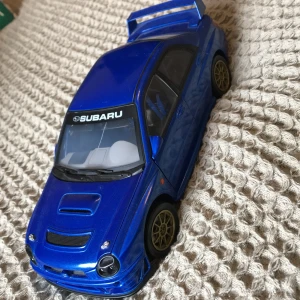 Model bil  - Blå subaru model bil i jättefint skick har en liten spricka i rutan