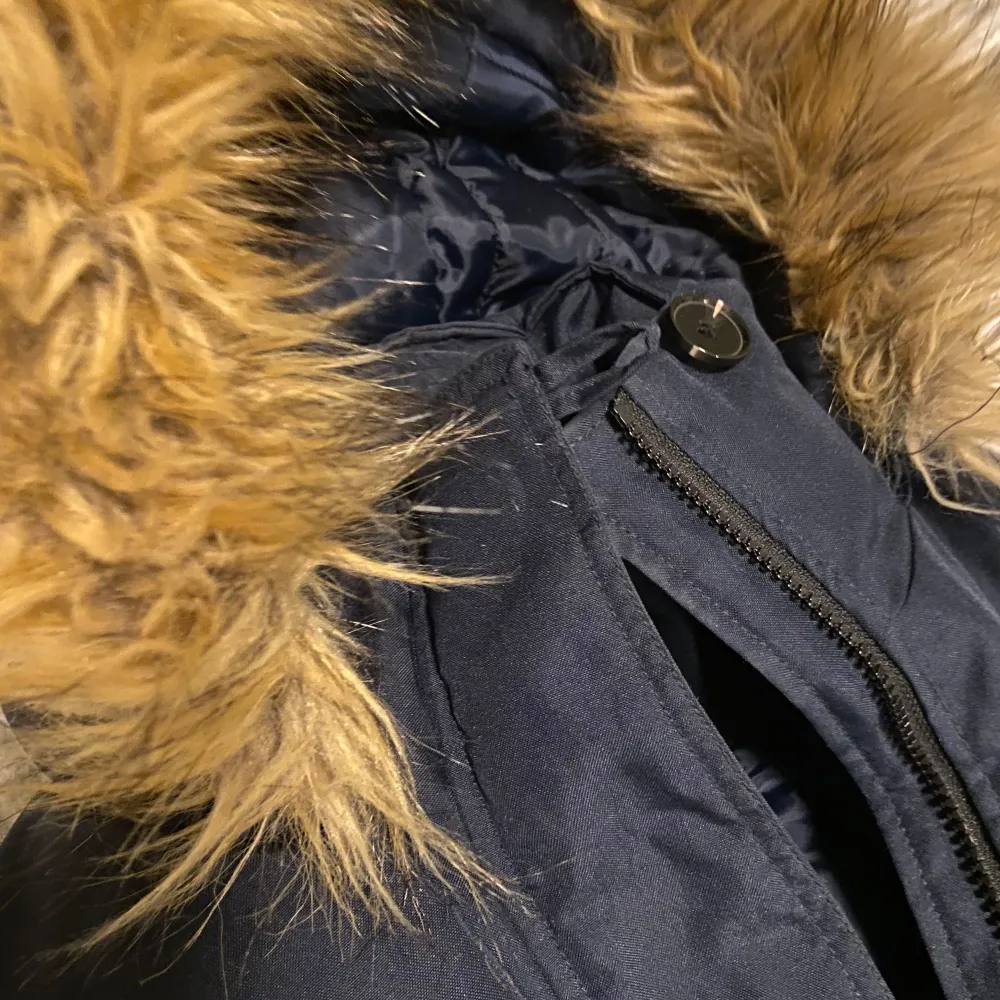 Snygg svart parkajacka från Vero Moda med fuskpäls på huvan. Jackan har dragkedja och knappar framtill samt praktiska fickor. I bra skick ☺️. Takit.