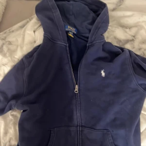 Ralph lauren kofta  - Säljer min mörkblåa Ralph lauren kofta med text på baksidan av huvan. Säljs för att den inte kommer till användning. Pris kan diskuteras!