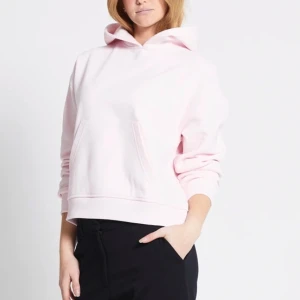 Ljusrosa hoodie - Säljer en ljusrosa hoodie med en stor ficka framtill och en bekväm huva. Tröjan har långa ärmar och en avslappnad passform, perfekt för en casual look. Passar bra till både jeans och leggings.