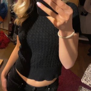 Svart stickad topp - Snygg svart stickad topp med ett diskret mönster. Toppen är croppad och har korta ärmar, perfekt för en stilren look. Passar bra till både jeans och kjol. Storlek Xs från Missay!! Använt skick, lite nopprig 