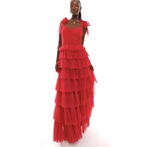 Röd långklänning med volanger - Fantastiskt fin röd långklänning som man exempelvis kan ha till balen. Så fina tylllager och knyten vid axlarna. Nypris 1425kr. Helt slutsåld. Priset kan diskuteras vid snabbt köp. Jag säljer då jag inte var helt nöjd med den. Sitter bra på mig som är en S/M. Skriv privat för egna bilder. 