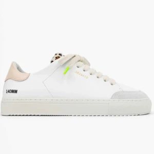 Vita sneakers från Axel Arigato - Stilrena vita sneakers med rosa och grå detaljer från Axel Arigato. Skorna har en  leopardmönstrad snörning och subtila gröna accenter. Perfekta för en modern och trendig look.