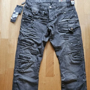 Grå jeans med detaljer - Snygga grå jeans med flera fickor och unika detaljer. Nyskick, nypris 600kr Modellen på bilden är 176 och har vanligtvis storlek S men byxorna är både för stora och för långa på modellen  Märke: Japrag Denim  Storleken står 31 men jag tycker att jeansen passar som en M/L  Midja: 44cm Innerbenslängd: 85cm Ytterbenslängd: 108cm 