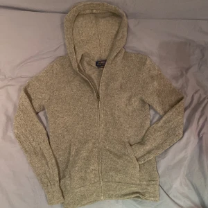  hoodie Polo Ralph Lauren - Säljer en stilren grå hoodie från Polo Ralph Lauren. Den har en dragkedja framtill och en broderad logga på bröstet. 70% bumull och 30% Kashmir.Perfekt för en avslappnad stil. Det står stolen L men den är som en S. Annars inga defekter.