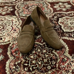 Bruna mockaloafers - Snygga bruna loafers i mocka med klassisk design. Perfekta för en stilren look. Skorna har en slät sula och är utan snörning för enkel påtagning.