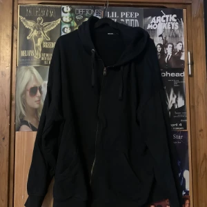 Svart hoodie från Bik Bok - Säljer en svart hoodie från Bik Bok med dragkedja och huva. Perfekt för en avslappnad stil. Den har långa ärmar och en klassisk passform. Hör av dig vid intresse!